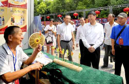 余學(xué)友察看“中國(guó)農(nóng)加工洽談會(huì)”非物質(zhì)文化遺產(chǎn)展展區(qū)